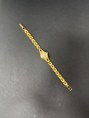 a close up of a gold watch on a black surface