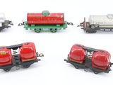 four toy trains on a white surface one is red and the other is green