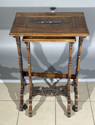 a small wooden table with writing on it on a tile floor