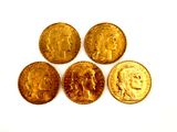 four different types of gold coins sitting on top of a white surface