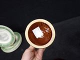 a person holding a small bowl of chocolate pudding