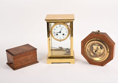 une petite horloge posée à côté d'une petite boîte en bois