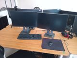 two computer monitors and a keyboard on a desk