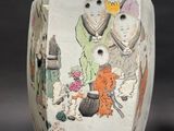 a vase with a painting on it sitting on a table