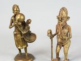 pair of bronze figurines of a man and a woman with a basket