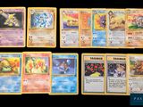 Plusieurs cartes Pokémon sont alignées sur une surface noire