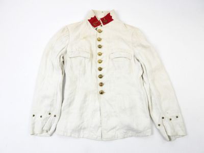 une vieille veste blanche avec un nœud rouge au col