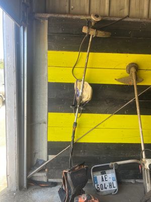 mur de garage rayé de jaune et de noir, sur lequel sont posés des outils
