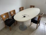 a white table with four chairs around it in a room