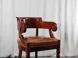 une chaise en bois avec une assise en cuir marron, posée sur un parquet