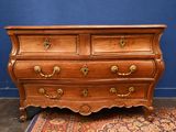 an antique chest of drawers on a rug in front of a blue wall