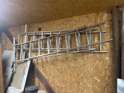 une échelle accrochée au mur du garage
