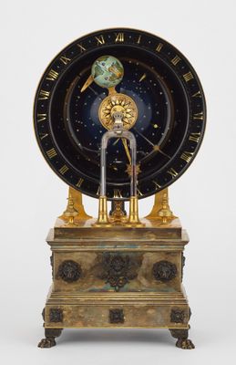 une horloge posée sur un socle orné d'un oiseau