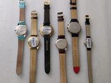 several different watches are lined up on a white surface