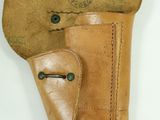 an old leather holster with a hand holding it up to it