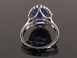 a blue sapphire and diamond ring on a black surface