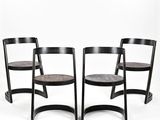 trois chaises en bois noires placées les unes à côté des autres sur une surface blanche