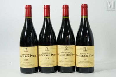 quatre bouteilles de vin sont alignées sur une surface blanche