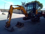 une petite excavatrice garée sur un parking