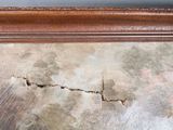 a crack in the wall of a room that has been damaged
