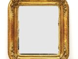 un miroir ancien dans un cadre doré, avec un fond blanc