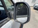 a side view mirror of a car on the side of the road