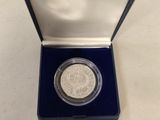 a small silver coin in a blue box on a table