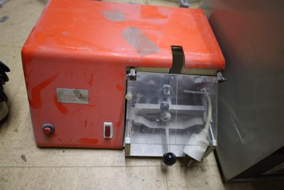 a small orange machine that is sitting on the floor