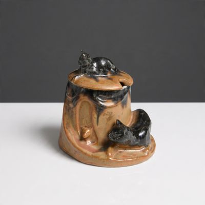 une figurine en céramique représentant un chat et une souris posée sur une table