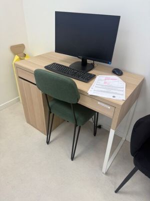 un bureau avec un ordinateur et une chaise dans un coin