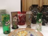 de nombreux vases et assiettes posés sur la table, décorés de fleurs
