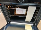un four noir sur la porte duquel est accrochée une pancarte