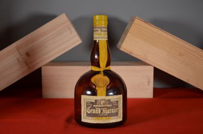 a bottle of liquor sitting on a table next to a wooden box