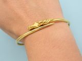 a close up of a person ' s hand wearing a gold bracelet