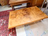 a wooden table with a wooden top on a rug