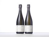 two bottles of wine sit side by side on a table