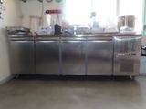 une grande cuisine en inox avec beaucoup d'espace de plan de travail