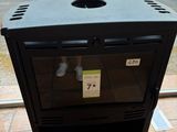 a black stove sitting on a brick floor in front of a window