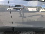 a reflection of a man standing in the door of a car