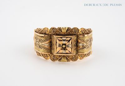 un gros plan d'une bague en or ornée d'un motif carré