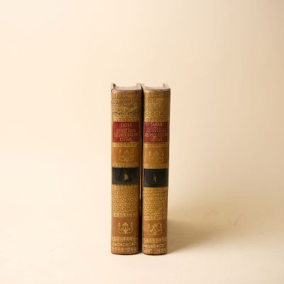 deux vieux livres posés l'un sur l'autre sur une surface blanche