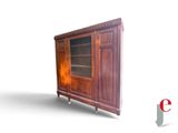 a wooden cabinet with a glass door on wheels