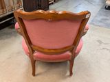 a pink chair that is sitting in the middle of a room