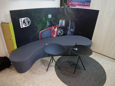 deux tables et un canapé dans une pièce où est accroché un tableau au mur