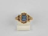 a gold ring with a blue stone in the center