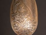a silver spoon with a floral design on it