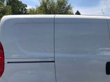 a white van parked in a parking lot with trees in the background