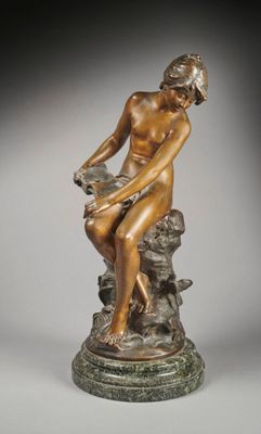 an image of a bronze statue of a woman sitting on a rock