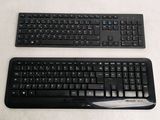 two keyboards sitting next to each other on a white surface