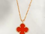 une chaîne en or avec un pendentif en forme de fleur rouge